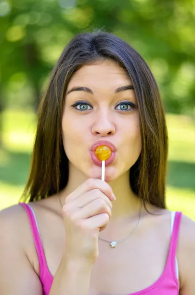 Funny portrait of girl licking lollipop — Stock Photo, Image