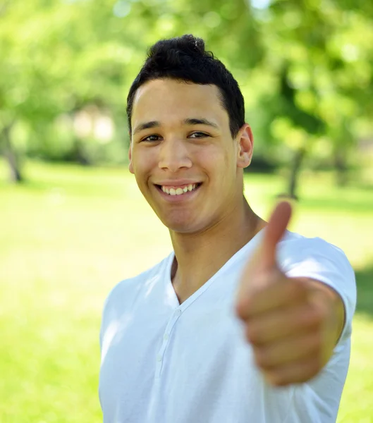 Jonge lachend met duim tegen aard achtergrond — Stockfoto