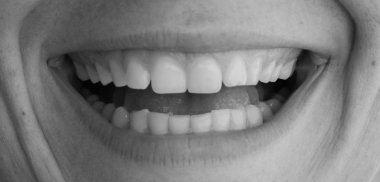 Güzel, sağlıklı bir kadın, siyah beyaz gülümser.