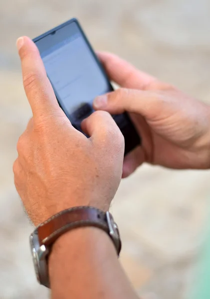 Fechar de um homem usando telefone inteligente móvel — Fotografia de Stock