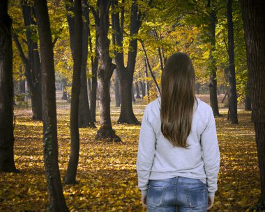 Sonbahar ormanlarında yürüyen bir kadın