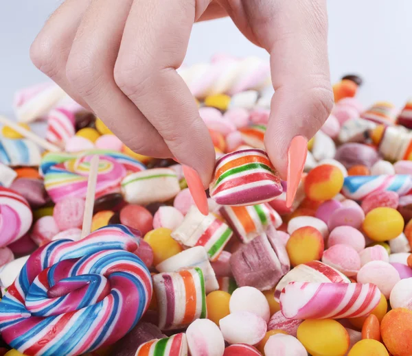 Mão agarrando doces da pilha - Conceito de problema de excesso de peso — Fotografia de Stock