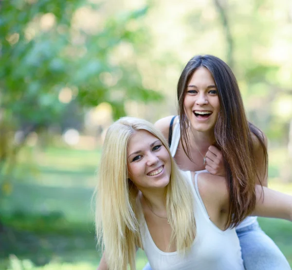 Close up portrait of two happy girls hugging outdoors — Stock Photo, Image