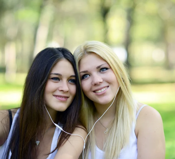 Two teenage girls listening to music outdoors — Stock Photo, Image