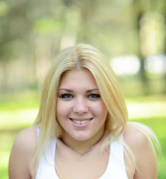 Portret van gelukkig meisje met blonde haren buitenshuis — Stockfoto