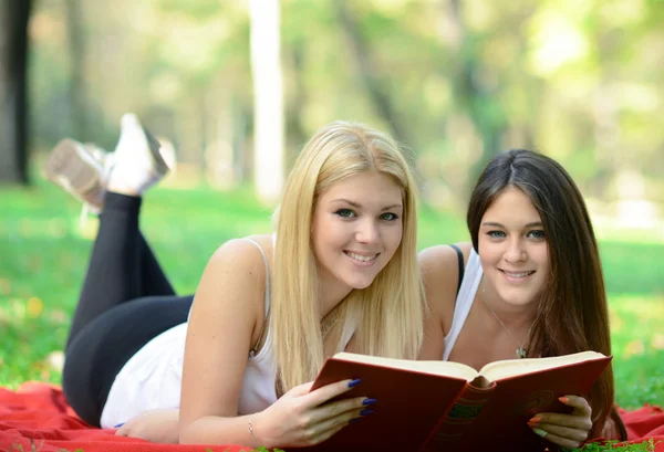 Dos chicas leyendo libro en el parque — Foto de Stock