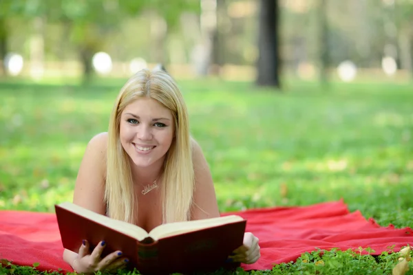 Feliz sorridente mulher ler livro no parque — Fotografia de Stock