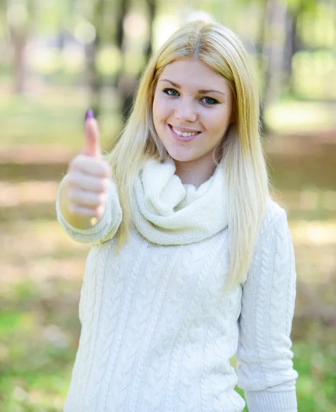 Portrait of beautiful girl holding thumbs up outdoors — Stock Photo, Image