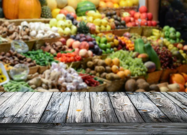 Background with empty wooden table and blured fruits and vegetab — Stock Photo, Image