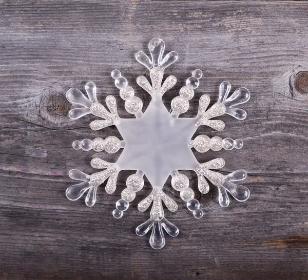Χριστουγεννιάτικο διακοσμητικό στολίδι - νιφάδα χιονιού σε ξύλινα φόντο — Φωτογραφία Αρχείου