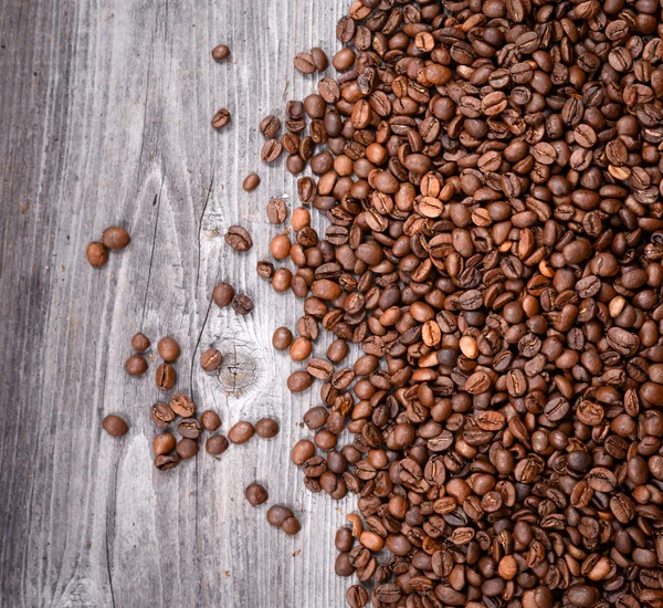 Grãos de café em fundo de madeira — Fotografia de Stock