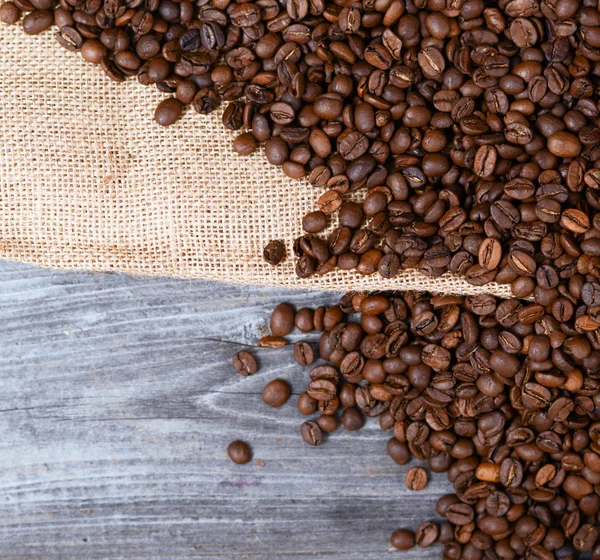 Saco de grãos de café em fundo de madeira — Fotografia de Stock