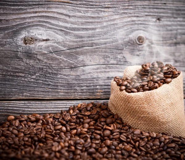 Sack of fresh coffee beans with smoke — Stock Photo, Image