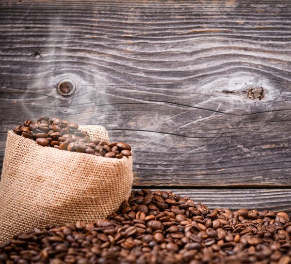 Sack of fresh coffee beans with smoke — Stock Photo, Image