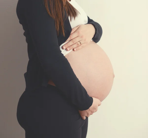 Pregnant woman holding belly with hands — Stock Photo, Image