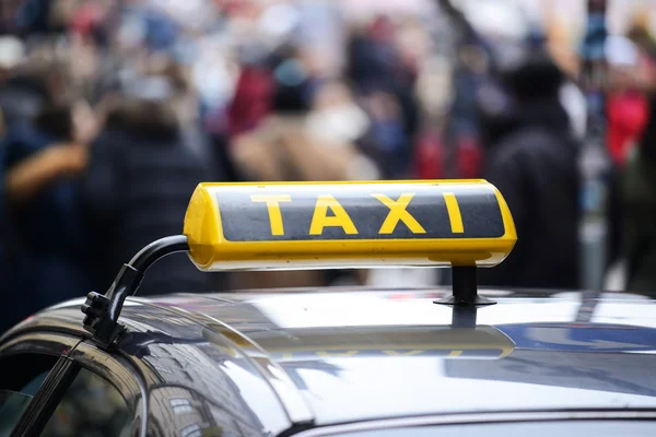 Taxi auto in centrum van de stad vol met voetgangers — Stockfoto