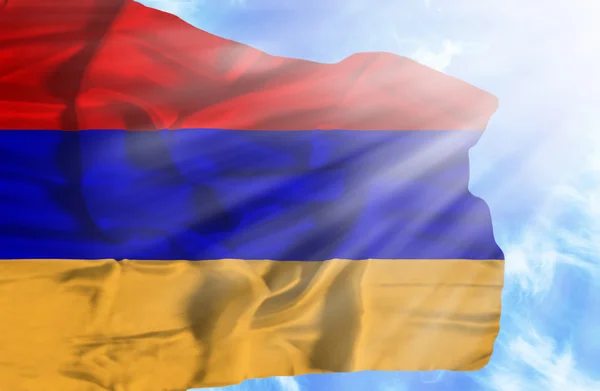 Armenien vinker flag mod blå himmel med solstråler - Stock-foto