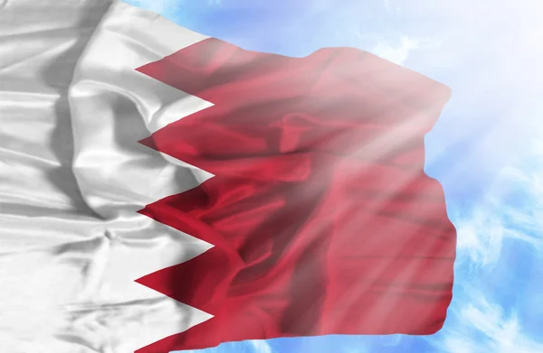 Бахрейн машет флагом на фоне голубого неба с солнечными лучами — стоковое фото