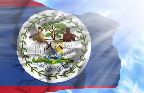 Belize sventola bandiera contro il cielo blu con i raggi del sole — Foto Stock