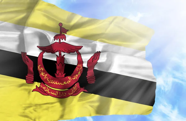 Brunei ondeando bandera contra el cielo azul con rayos de sol — Foto de Stock