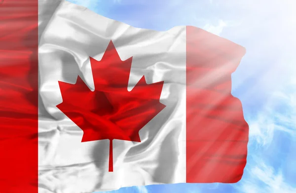 Canada zwaaien vlag tegen blauwe hemel met zonnestralen — Stockfoto