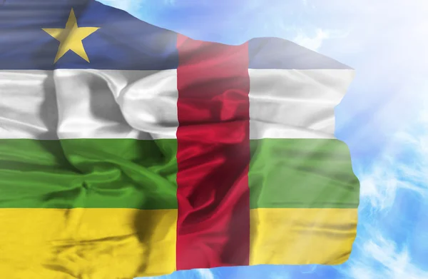 Zentralafrikanische Republik schwenkt Flagge gegen blauen Himmel mit Sonne — Stockfoto