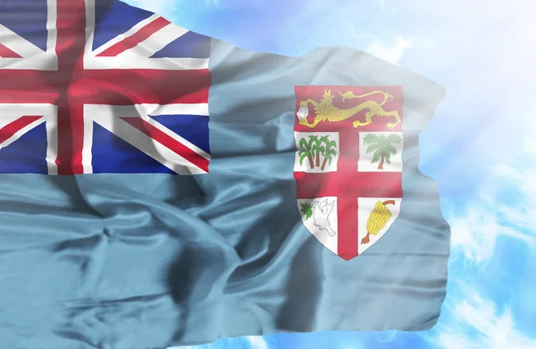 Fiji waving flag against blue sky with sunrays — Stock Photo, Image