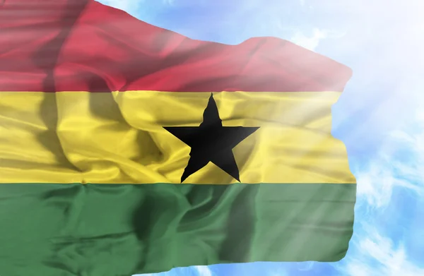 Ghana ondeando bandera contra el cielo azul con rayos de sol — Foto de Stock