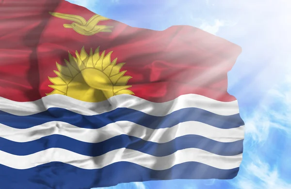 Kiribati zwaaien vlag tegen blauwe hemel met zonnestralen — Stockfoto