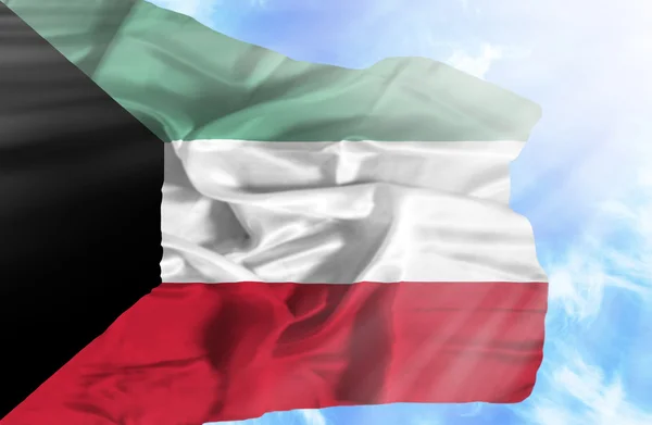 Kuwait schwenkt Flagge gegen blauen Himmel mit Sonnenstrahlen — Stockfoto