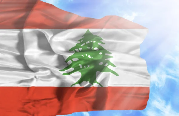 Libanon zwaaien vlag tegen blauwe hemel met zonnestralen — Stockfoto
