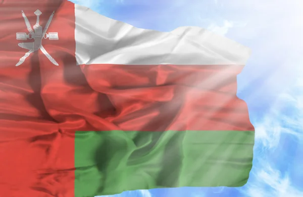 Oman vinker flag mod blå himmel med solstråler - Stock-foto