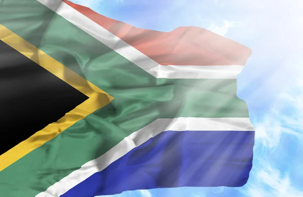 Südafrika schwenkt Flagge gegen blauen Himmel mit Sonnenstrahlen — Stockfoto