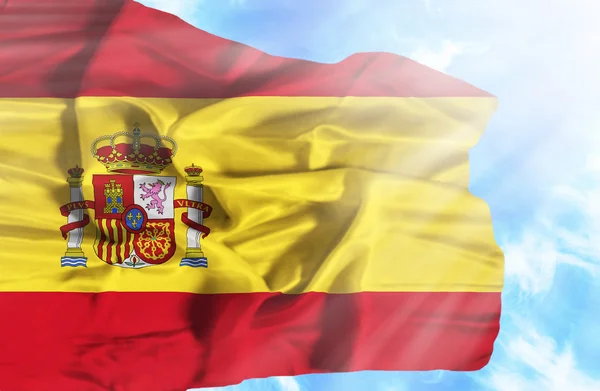 Spanien viftande flagga mot blå himmel med solstrålar — Stockfoto