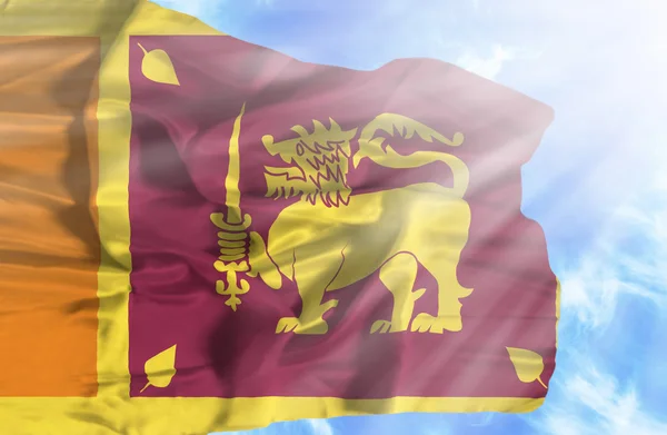Sri Lanka ondeando bandera contra el cielo azul con rayos de sol —  Fotos de Stock