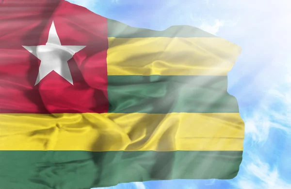 Togo sventola bandiera contro il cielo blu con i raggi del sole — Foto Stock