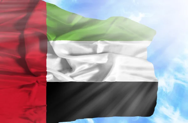 Émirats arabes unis agitant le drapeau contre le ciel bleu avec des rayons de soleil — Photo