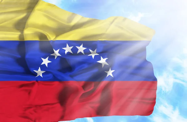 Venezuela viftande flagga mot blå himmel med solstrålar — Stockfoto