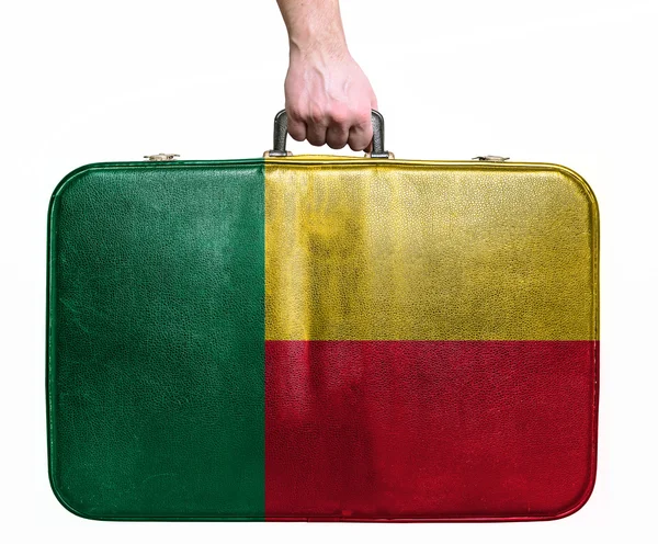 Tourist hand holding vintage leather travel bag with flag of Ben — Stock Photo, Image