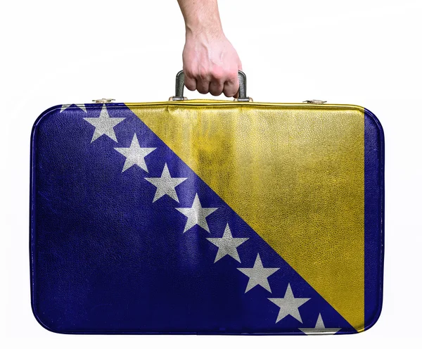 Tourist hand holding vintage leather travel bag with flag of Bos — Stock Photo, Image