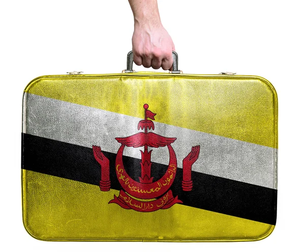 Tourist hand holding vintage leather travel bag with flag of Bru — Stock Photo, Image