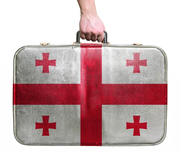 Turystyczne ręki trzymającej skórzany starodawny torba podróżna z flagą Geo — Zdjęcie stockowe