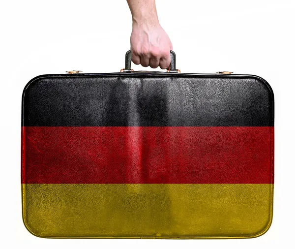 Touristenhand hält Reisetasche aus Vintage-Leder mit Ger-Flagge — Stockfoto