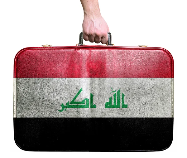 Tourist hand holding vintage leather travel bag with flag of Ira — Stock Photo, Image