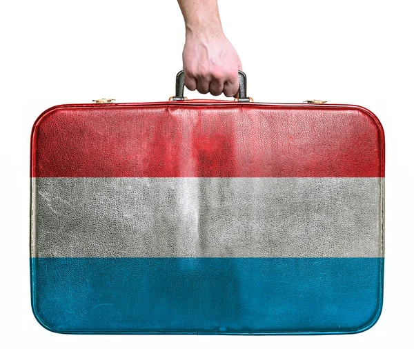 Tourist hand holding vintage leather travel bag with flag of Lux — Stock Photo, Image