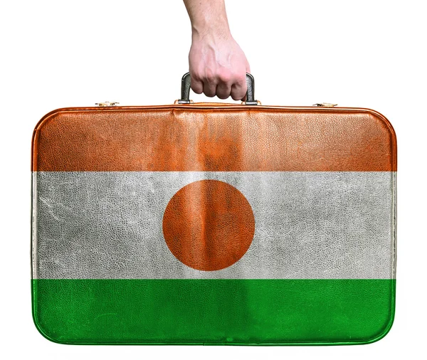 Tourist hand holding vintage leather travel bag with flag of Nig — Stock Photo, Image