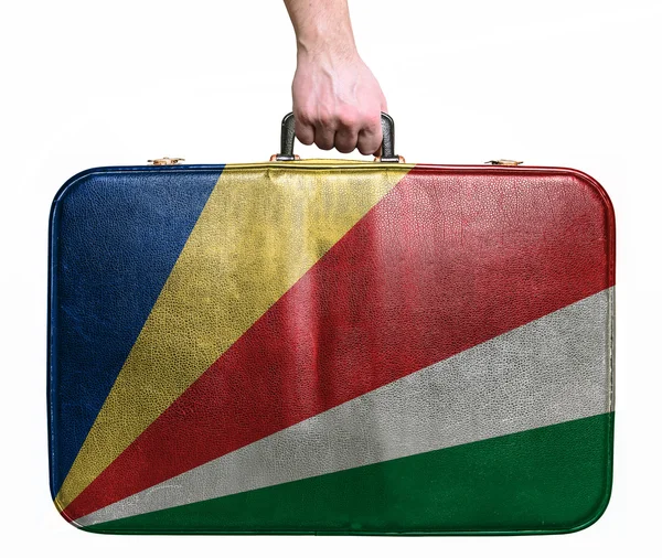 Tourist hand holding vintage leather travel bag with flag of Sey — Stock Photo, Image