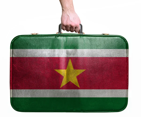 Tourist hand holding vintage leather travel bag with flag of Sur — Stock Photo, Image