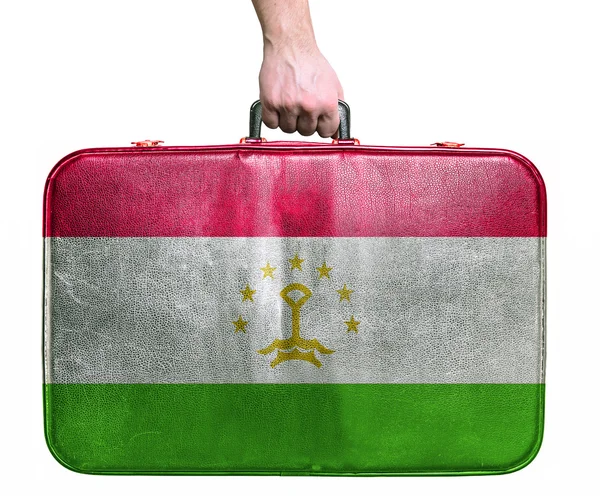 Tourist hand holding vintage leather travel bag with flag of Taj — Stock Photo, Image