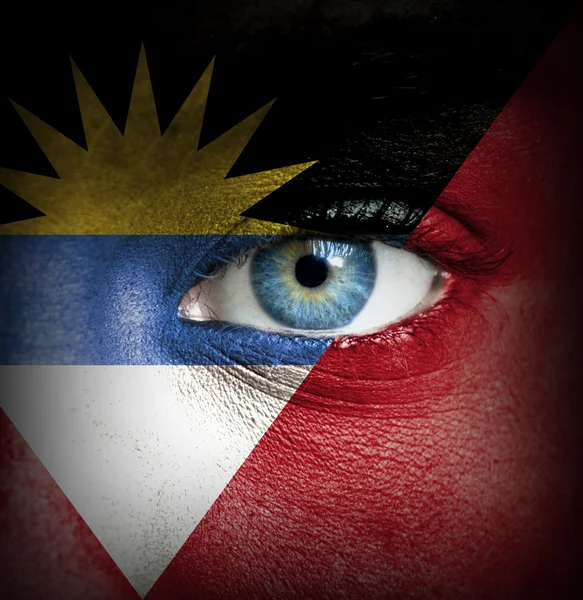 Human face painted with flag of Antigua and Barbuda — Stock Photo, Image